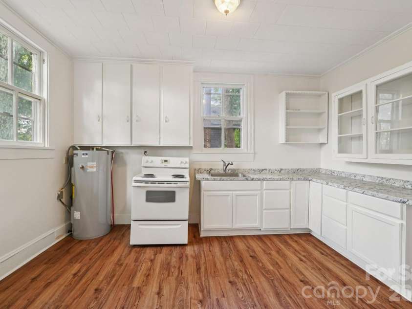 105 Houston Street, Monroe, NC 28112.  MLS# CAR4396106, YatesRealty ID 33807. Primary Unit: Kitchen featuring updated glass-front cabinetry, ample workspace, and plenty of storage.
