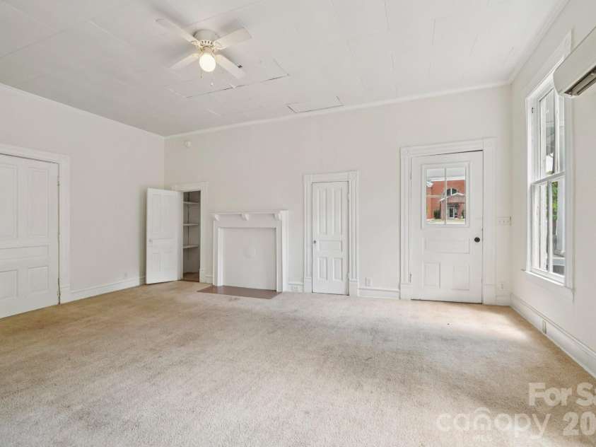 105 Houston Street, Monroe, NC 28112.  MLS# CAR4396106, YatesRealty ID 33807. Secondary Unit: Bedroom featuring generous space and direct access to additional living areas, offering flexibility as the home is reimagined as a single-family residence.