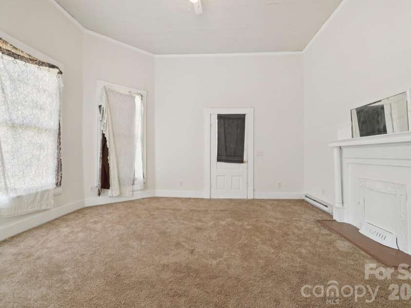 105 Houston Street, Monroe, NC 28112.  MLS# CAR4396106, YatesRealty ID 33807. Secondary Unit: Living room featuring original architectural character and a comfortable gathering space.