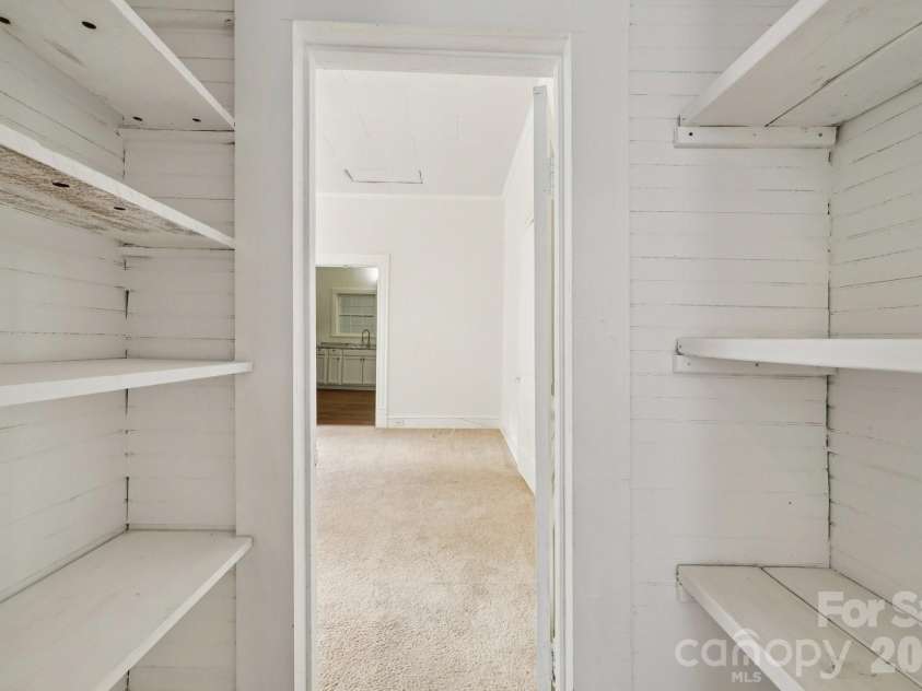 105 Houston Street, Monroe, NC 28112.  MLS# CAR4396106, YatesRealty ID 33807. Secondary Unit: Spacious walk-in pantry and storage area offering exceptional organization and utility.