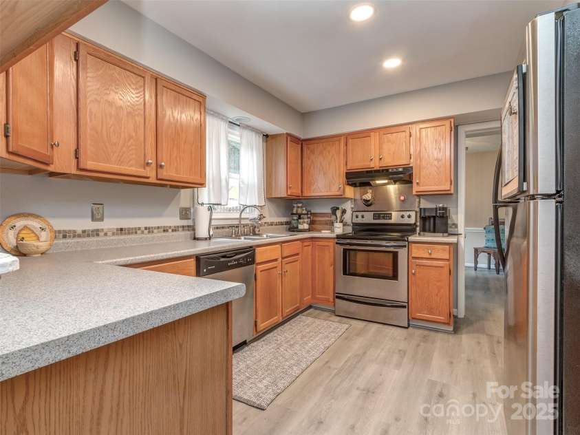 8715 Parkchester Drive, Charlotte, NC 28277.  MLS# CAR4288901, YatesRealty ID 33815. Kitchen has mosaic tile backsplash, laminate wood flooring, stainless appliances, pantry & is open to the breakfast area & dining room.