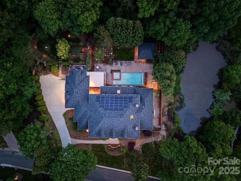 3314 Leamington Lane, Charlotte, NC 28226.  MLS# CAR4252556, YatesRealty ID 33832. Aerial view showcasing the solar panels, gardens, pool, and adjacent pond.