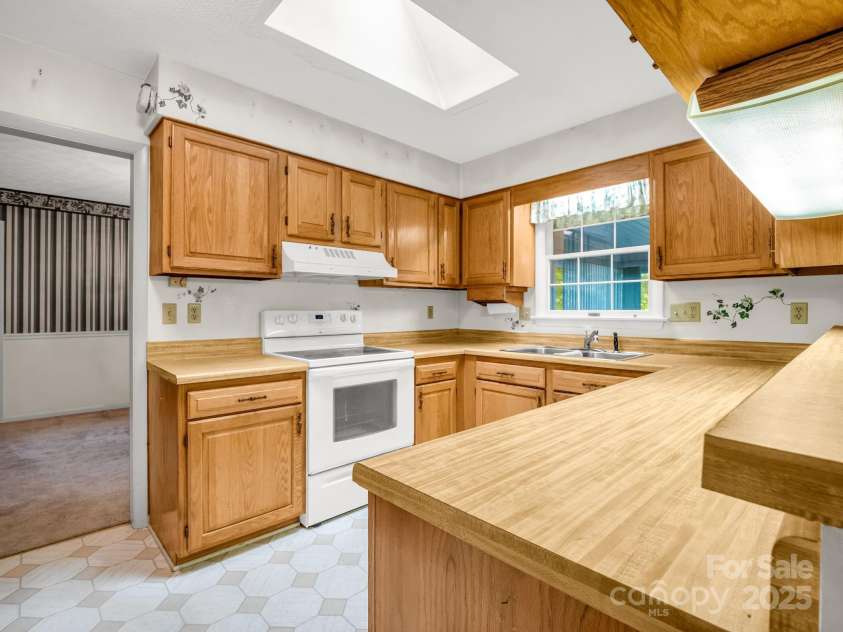 845 Greenwood Drive, Hendersonville, NC 28791.  MLS# CAR4290151, YatesRealty ID 33859. Kitchen between dining room and family room