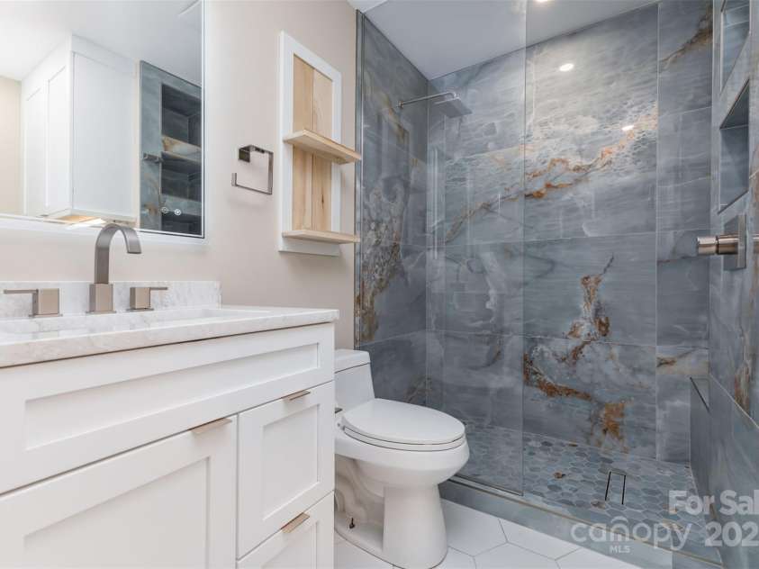 7308 Barn Stone Drive, Charlotte, NC 28227.  MLS# CAR4278388, YatesRealty ID 33885. Beautiful remodeled primary bathroom with tile and dual split vanities