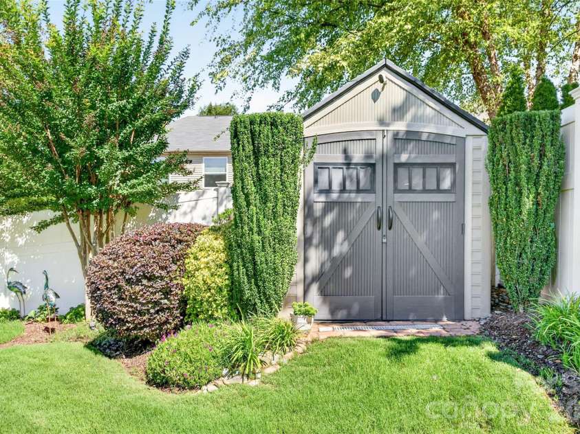 103 Cranbrook Lane, Mooresville, NC 28117.  MLS# CAR4392478, YatesRealty ID 33887. Charming storage building tucked discreetly into the landscaping with double doors and ample space.