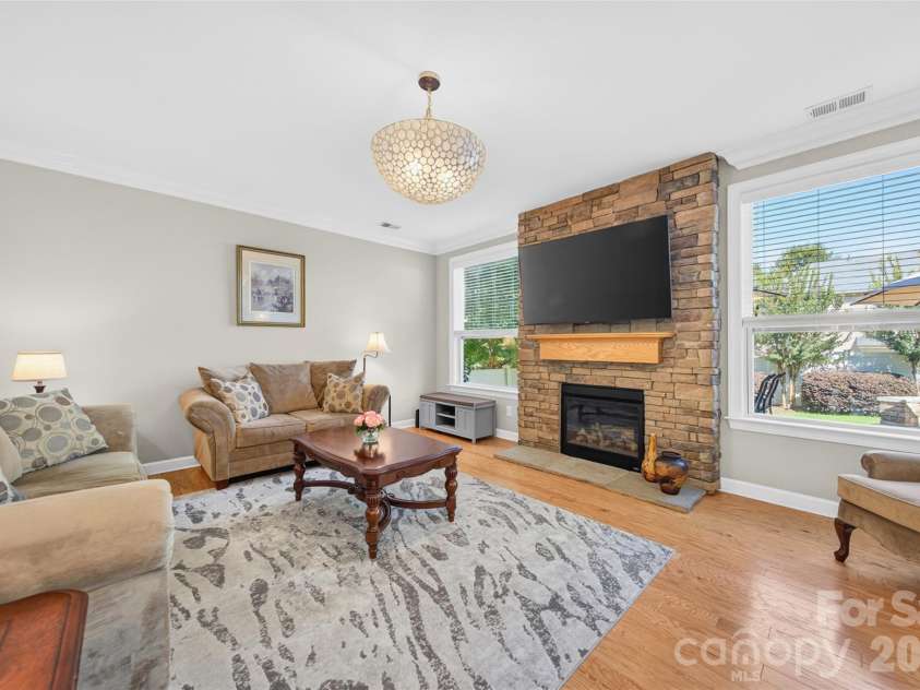 103 Cranbrook Lane, Mooresville, NC 28117.  MLS# CAR4392478, YatesRealty ID 33887. Inviting living area featuring a gas fireplace flanked by windows with views of the landscaped backyard.