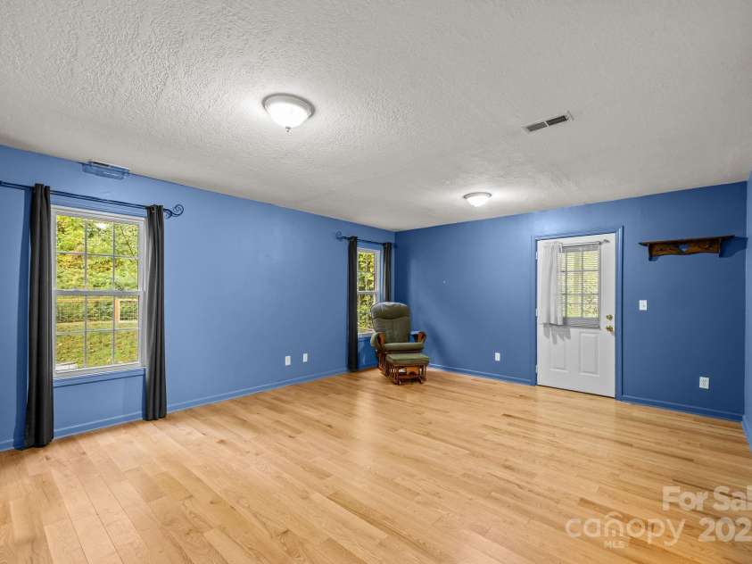 73 Waters Road, Asheville, NC 28805.  MLS# CAR4272719, YatesRealty ID 33907. Large primary ensuite bedroom w/ walk-in closet and walkout access to covered back porch.