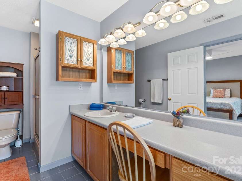 27 Eden Glen Road, Black Mountain, NC 28711.  MLS# CAR4292054, YatesRealty ID 33978. The spacious en suite bathroom offers ample counter space, generous storage, and a dedicated makeup or dressing area, making this primary suite feel like your own personal retreat.