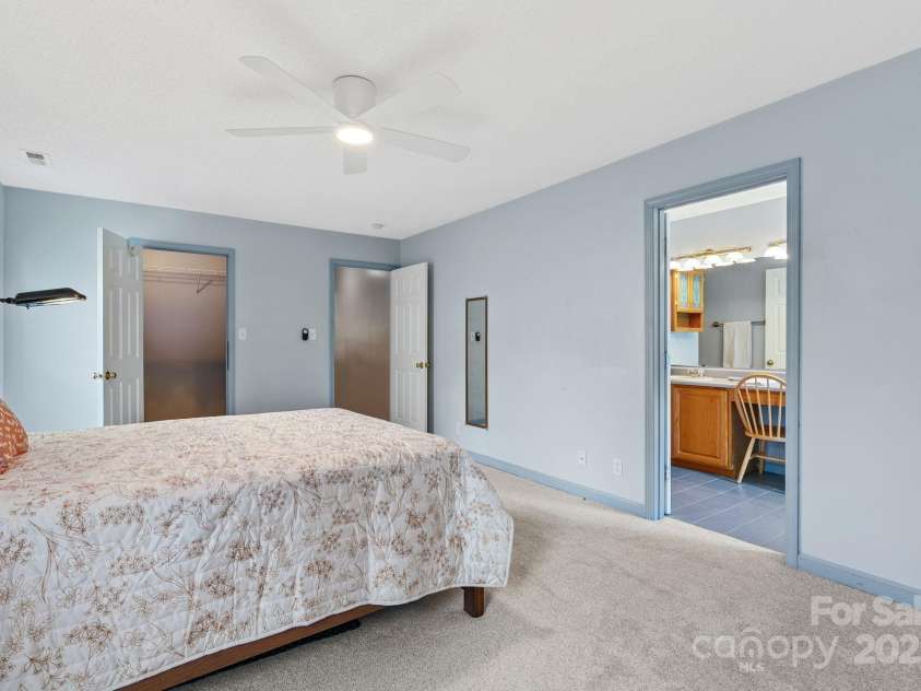 27 Eden Glen Road, Black Mountain, NC 28711.  MLS# CAR4292054, YatesRealty ID 33978. The spacious primary suite includes a large walk-in closet and direct access to a private en suite bathroom, offering both comfort and convenience.