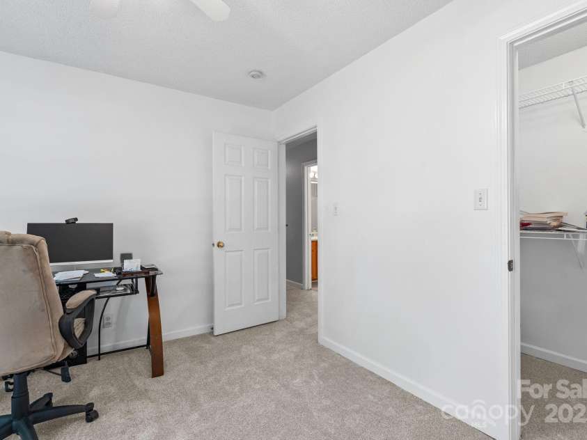 27 Eden Glen Road, Black Mountain, NC 28711.  MLS# CAR4292054, YatesRealty ID 33978. The third bedroom includes a spacious walk-in closet and neutral finishes, offering flexibility as a comfortable bedroom, home office, or creative space.