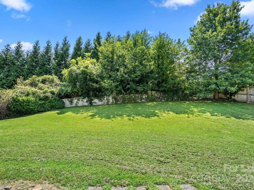 27 Eden Glen Road, Black Mountain, NC 28711.  MLS# CAR4292054, YatesRealty ID 33978. This large, level backyard is fully fenced for privacy and framed by mature trees, creating a peaceful outdoor retreat. With plenty of open space, it’s perfect for gardening, play, or entertaining in a private, natu