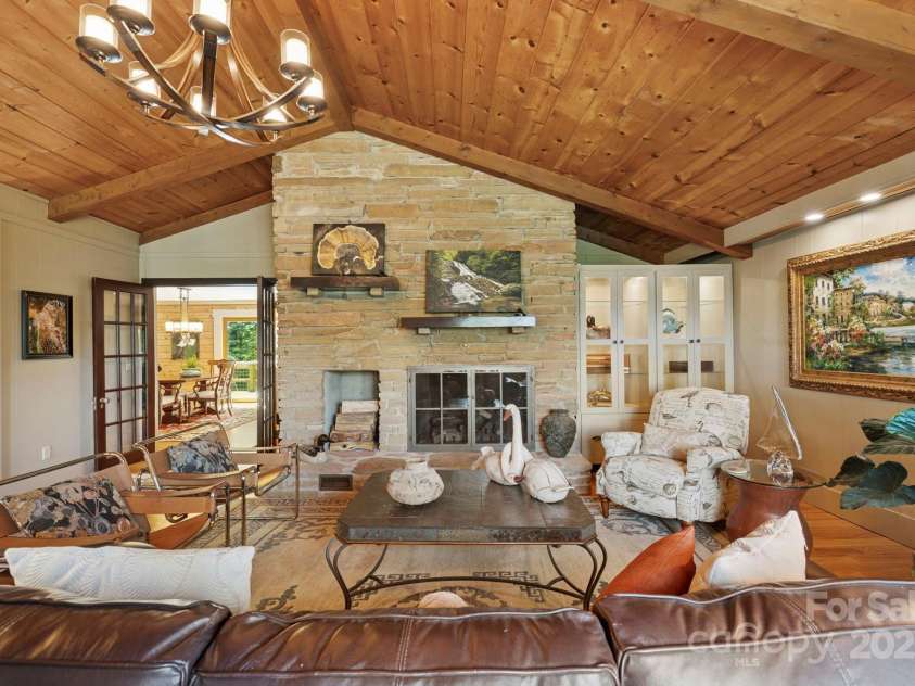 85 Rock Rest Road, Hendersonville, NC 28739.  MLS# CAR4282137, YatesRealty ID 33979. Modern vibe living area with hardwood floors, magnificent stone fireplace, built in cabinetry and french doors