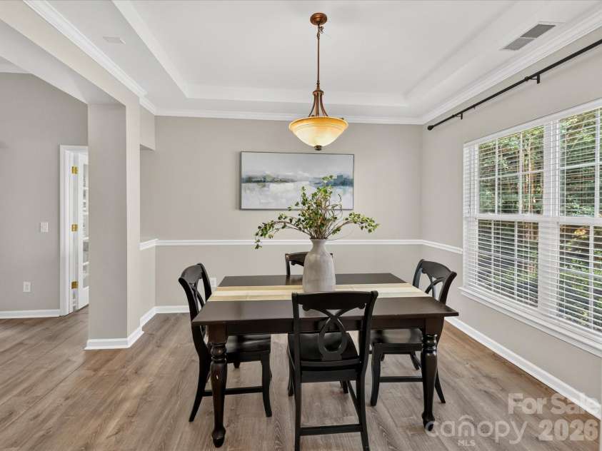 18418 Torrence Chapel Estates Circle, Cornelius, NC 28031.  MLS# CAR4392160, YatesRealty ID 34069. The elegant dining room features crown molding, chair rail detailing, abundant natural light, and ample space for hosting memorable gatherings and holiday celebrations.
