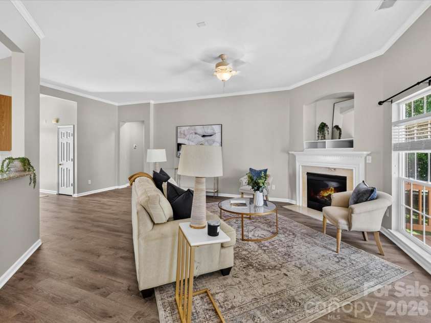 18418 Torrence Chapel Estates Circle, Cornelius, NC 28031.  MLS# CAR4392160, YatesRealty ID 34069. The spacious family room features soaring ceilings, abundant natural light, updated flooring, and a cozy fireplace, creating the perfect setting for both relaxing and entertaining.