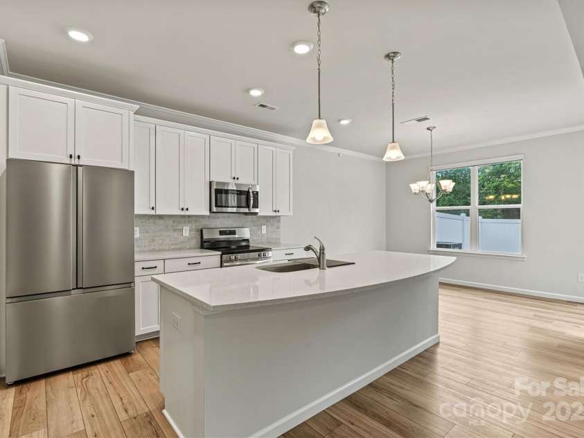 8233 Merryvale Lane, Charlotte, NC 28214.  MLS# CAR4293433, YatesRealty ID 34155. Flooded with natural light, this kitchen shines with sleek stainless steel appliances—including a refrigerator with built-in water dispenser, all ready for move-in convenience.