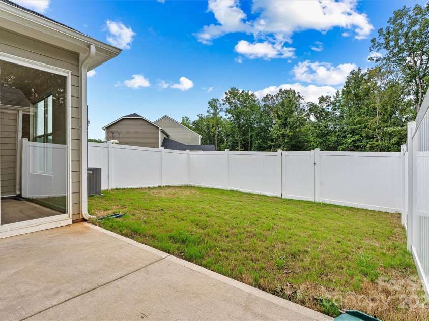 8233 Merryvale Lane, Charlotte, NC 28214.  MLS# CAR4293433, YatesRealty ID 34155. Step through the sliding doors on the main level and into your private backyard oasis—featuring a cozy patio area and lush green space, perfect for outdoor dining, play, or peaceful relaxation
