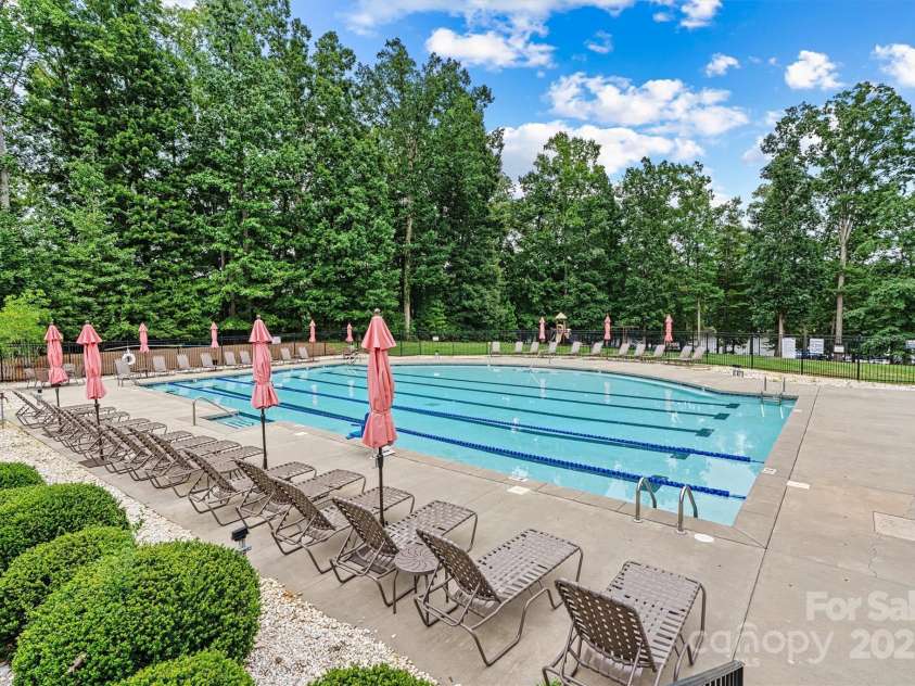 8233 Merryvale Lane, Charlotte, NC 28214.  MLS# CAR4293433, YatesRealty ID 34155. The community features two beautiful pools—one designed just for kids with playful sprayers and splash zones, and another expansive pool perfect for adults to swim laps, unwind, or soak up the sun in a serene setting