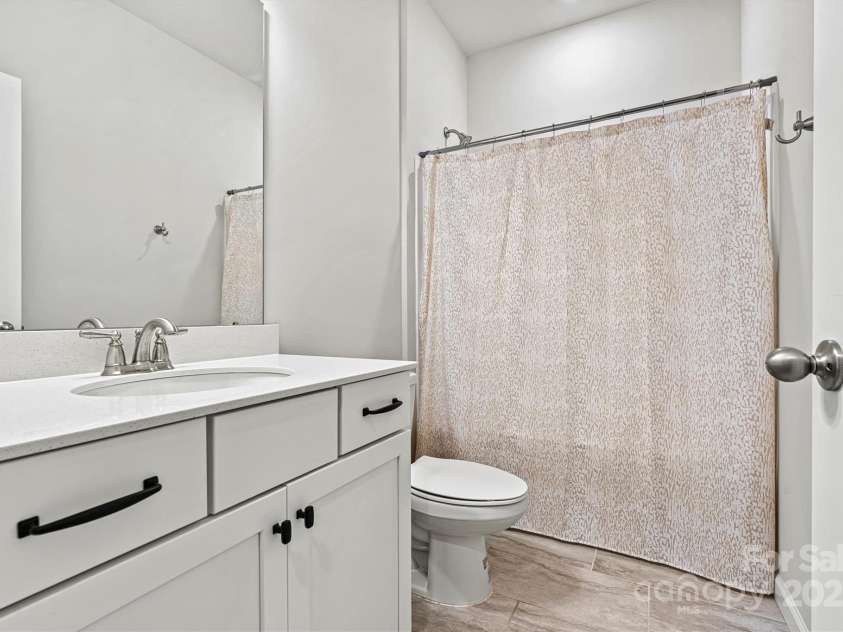 8233 Merryvale Lane, Charlotte, NC 28214.  MLS# CAR4293433, YatesRealty ID 34155. The secondary bedrooms share a spacious, beautifully tiled bathroom featuring a shower/tub combo and a generous vanity with ample drawer storag