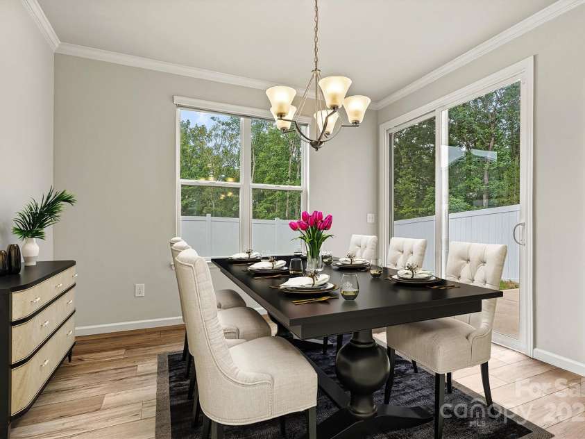 8233 Merryvale Lane, Charlotte, NC 28214.  MLS# CAR4293433, YatesRealty ID 34155. This virtually staged eat-in kitchen showcases a bright and airy space with oversized windows and sliding doors that open to your private backyard—complete with a spacious dining table offering plenty of seating for fa