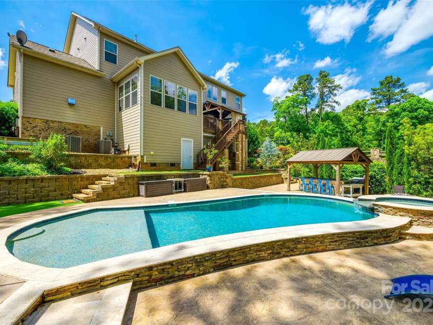 288 Ridge Reserve Drive, Lake Wylie, SC 29710.  MLS# CAR4249323, YatesRealty ID 34210. Backyard paradise.Lush landscaping surrounds a stunning pool, hot tub, and fire pit—your private escape for relaxation and unforgettable gatherings.