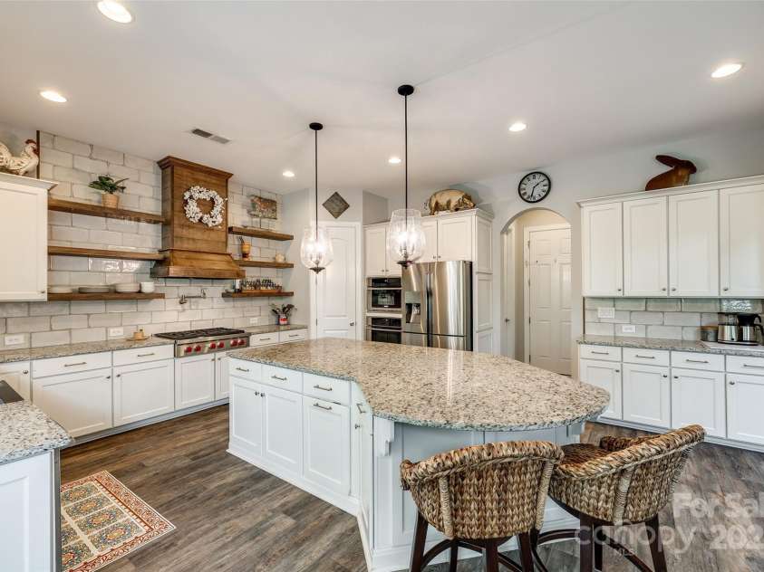 288 Ridge Reserve Drive, Lake Wylie, SC 29710.  MLS# CAR4249323, YatesRealty ID 34210. Crisp white cabinetry, granite countertops, and a warm wood range hood come together to create a timeless kitchen that’s both functional and full of charm.