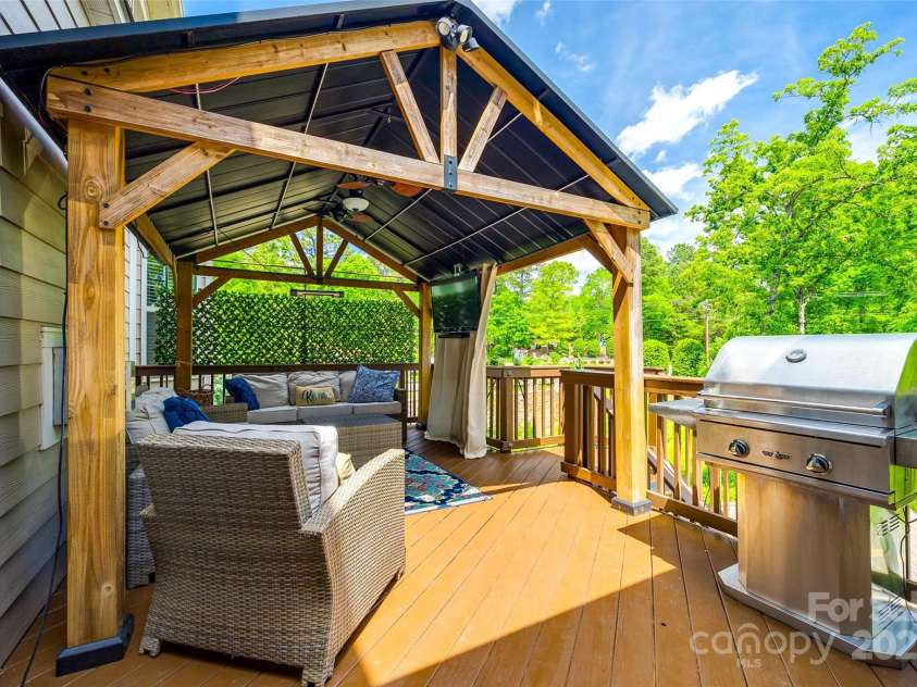 288 Ridge Reserve Drive, Lake Wylie, SC 29710.  MLS# CAR4249323, YatesRealty ID 34210. Elevate your outdoor living with this beautiful deck featuring a stylish covered seating area and built-in grill—perfect for weekend cookouts or evening unwinds.