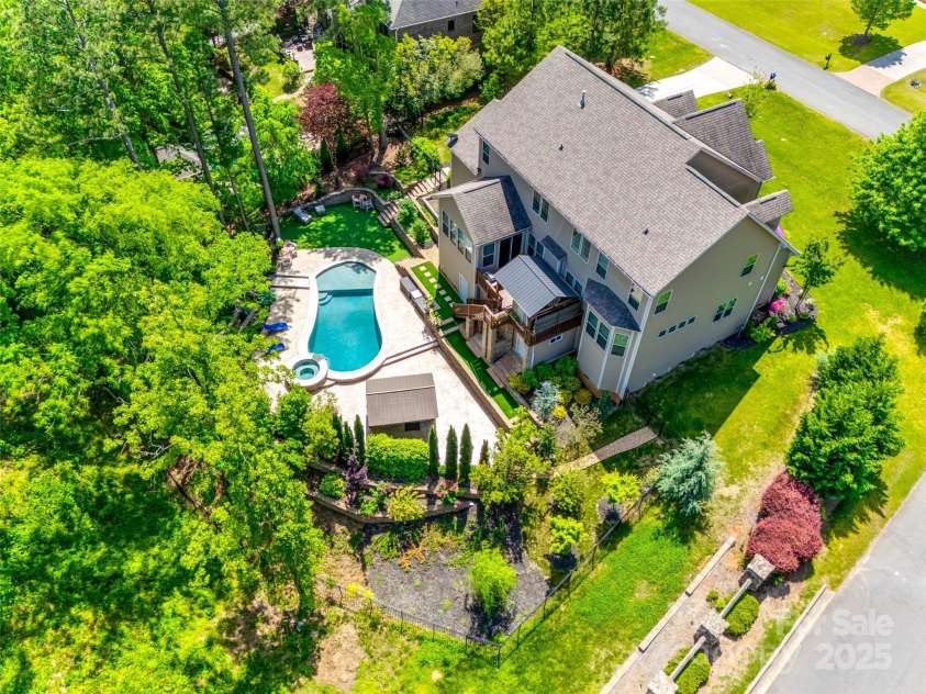 288 Ridge Reserve Drive, Lake Wylie, SC 29710.  MLS# CAR4249323, YatesRealty ID 34210. This aerial shot highlights the expansive backyard, showcasing the custom pool, covered patios, and lush landscaping in a serene setting.