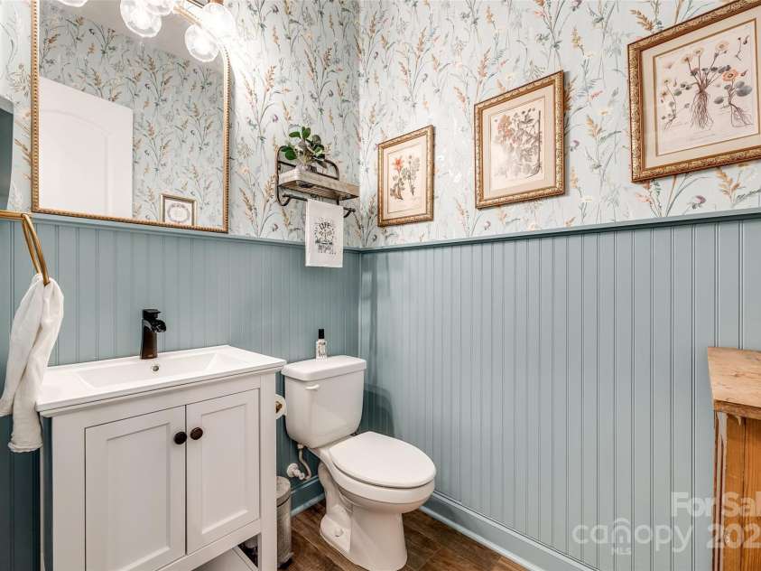 288 Ridge Reserve Drive, Lake Wylie, SC 29710.  MLS# CAR4249323, YatesRealty ID 34210. This stylish powder room blends vintage charm with modern flair, featuring botanical wallpaper, beadboard paneling, and curated details that make a lasting impression.
