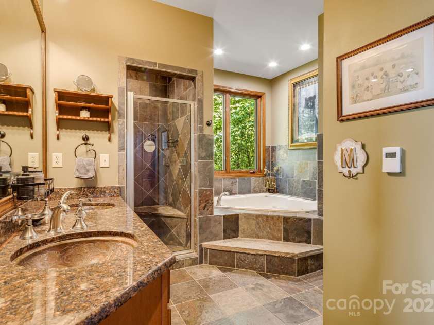 191 Ivy Way, Mars Hill, NC 28754.  MLS# CAR4308782, YatesRealty ID 3424. Main level ensuite primary bathroom with walk-in closets.