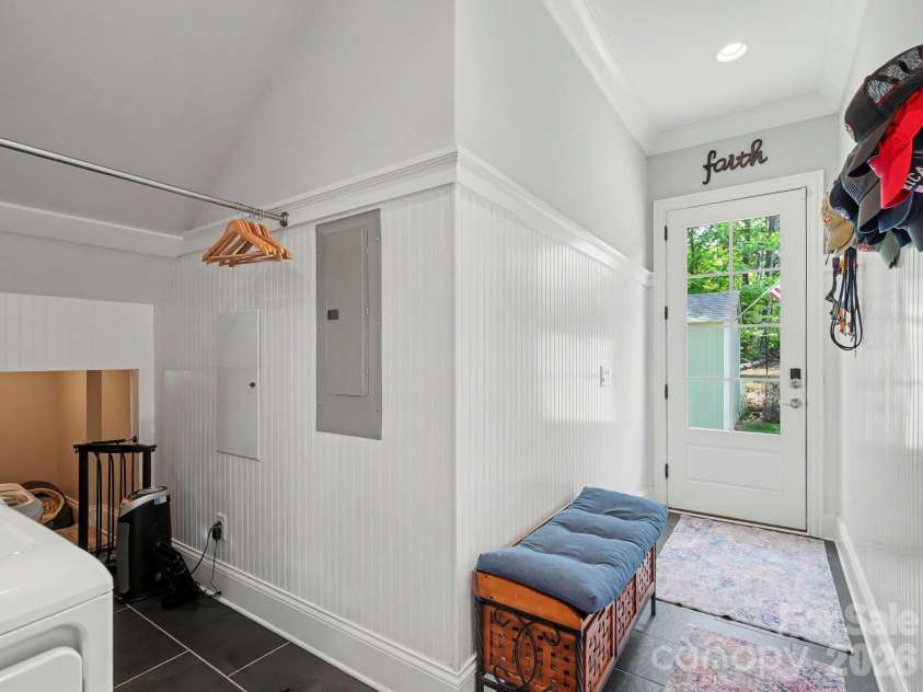 9560 Regent Drive, Davidson, NC 28036.  MLS# CAR4397866, YatesRealty ID 34310. Utility/mud room with dog sleeping room or storage space leads to side door inside fence