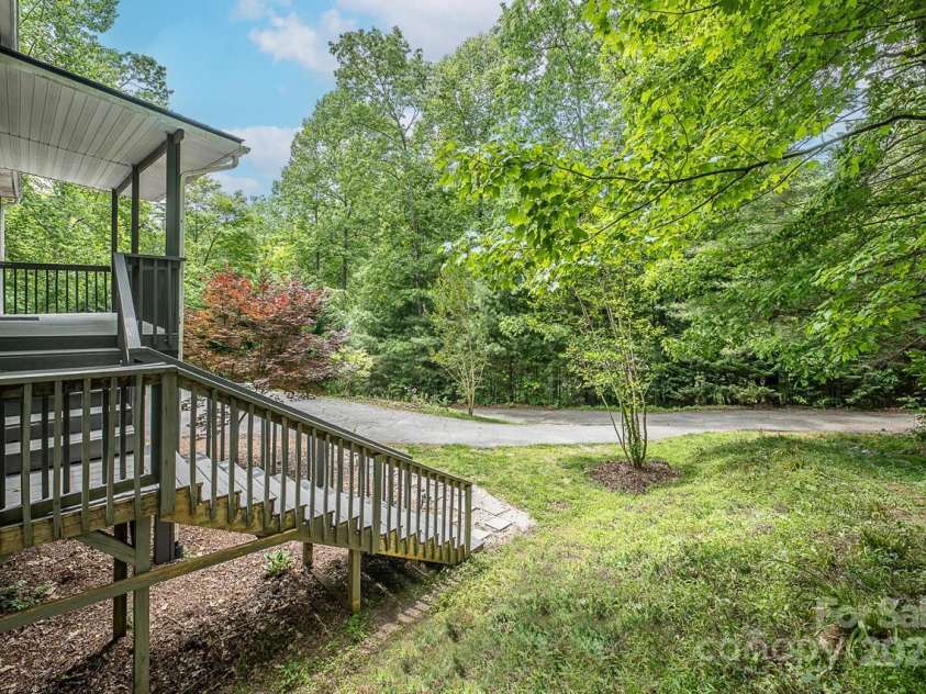 46 Badger Run, Hendersonville, NC 28739.  MLS# CAR4281037, YatesRealty ID 34340. Front entrance surrounded by flowering trees.