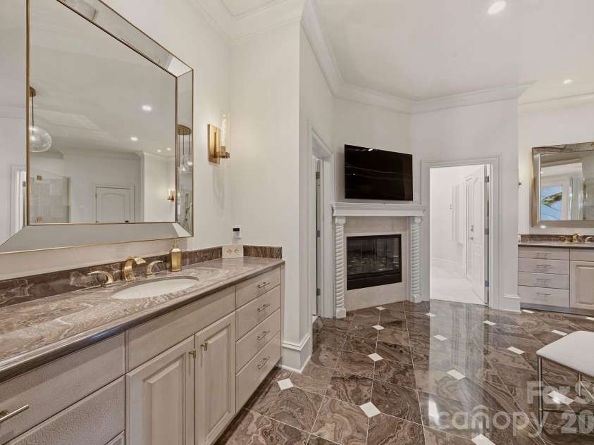 16920 Harbor Master Cove, Cornelius, NC 28031.  MLS# CAR4394741, YatesRealty ID 34351. Main-level primary ensuite with two vanities, fireplace, and private water closet. 