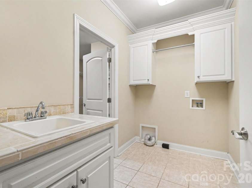 115 Blakemore Drive, Shelby, NC 28152.  MLS# CAR4393685, YatesRealty ID 34369. The laundry has a sink, storage beneath the sink and above the washer/dryer area, plus a hanging rod.
