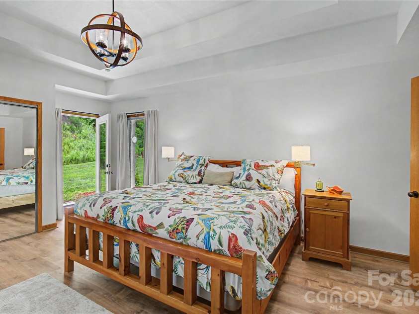 340 Earlys Mountain Road, Leicester, NC 28748.  MLS# CAR4398900, YatesRealty ID 34431. The spacious primary suite offers a peaceful retreat with private access to the covered back patio, two spacious closets, and plenty of room to relax.