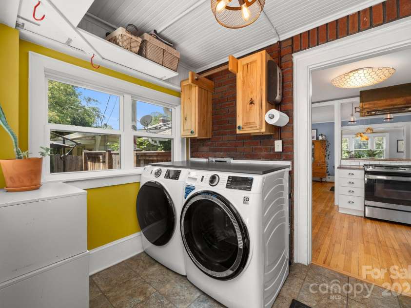 77 Mitchell Avenue, Asheville, NC 28806.  MLS# CAR4285971, YatesRealty ID 34450. Mud/Laundry room with cabinets, shelving and fixed and retractible hanger rods.