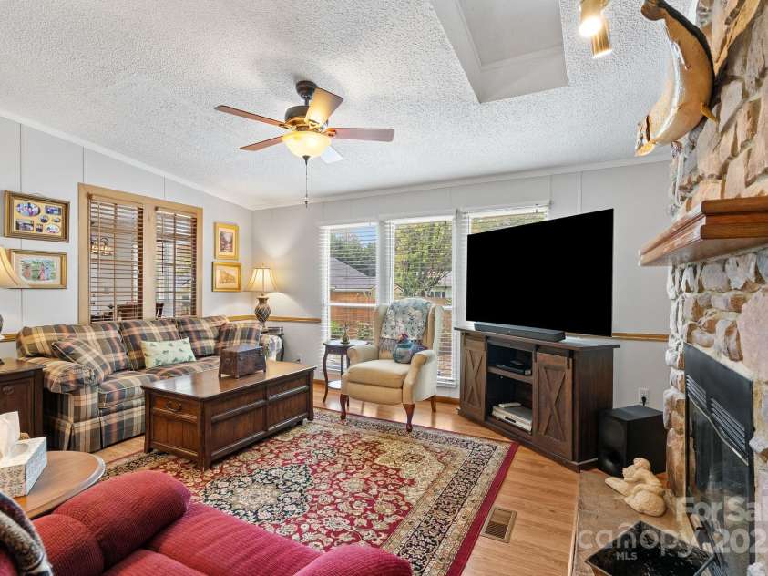 213 Old State Ten Road, Black Mountain, NC 28711.  MLS# CAR4294666, YatesRealty ID 34482. Another view of the family room showcases its abundance of natural light, with large windows that brighten the space and create a welcoming atmosphere.
