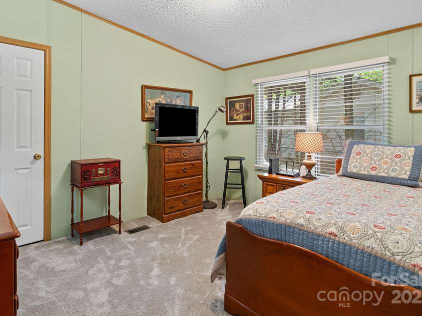 213 Old State Ten Road, Black Mountain, NC 28711.  MLS# CAR4294666, YatesRealty ID 34482. Bedroom #2 is generously sized and filled with natural light from large windows overlooking the side yard. Soft carpeting creates a cozy feel, while the neutral tones make it easy to personalize. Whether used a
