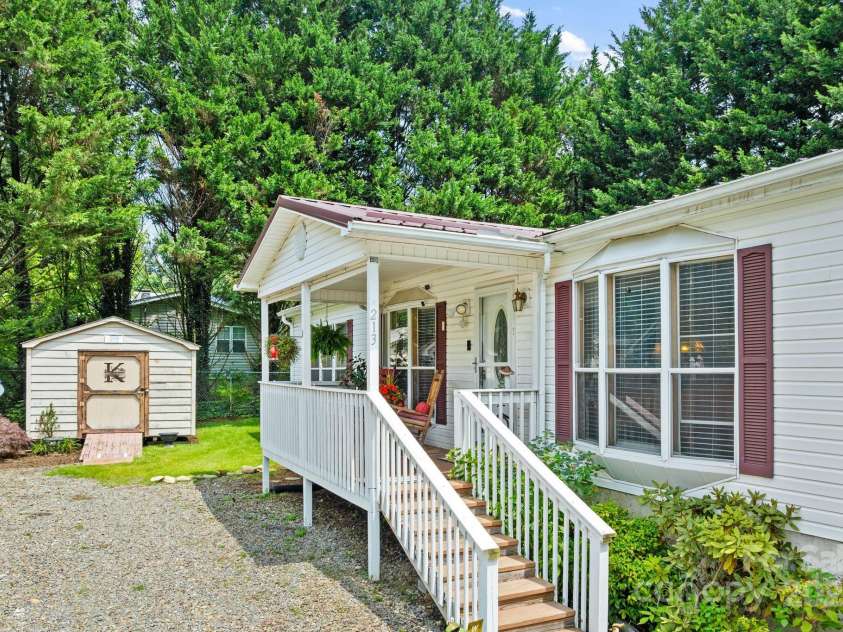 213 Old State Ten Road, Black Mountain, NC 28711.  MLS# CAR4294666, YatesRealty ID 34482. One of the standout features of this home is its metal roof, offering both durability and peace of mind. Large windows allow natural light to stream inside. A storage shed offers extra convenience.