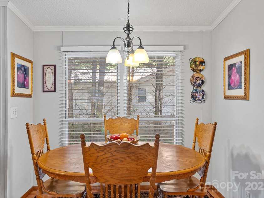 213 Old State Ten Road, Black Mountain, NC 28711.  MLS# CAR4294666, YatesRealty ID 34482. The cozy breakfast nook is filled with natural light from large windows that frame the space, creating the perfect spot to start your day. Whether enjoying a quiet morning coffee or casual meals with family, th