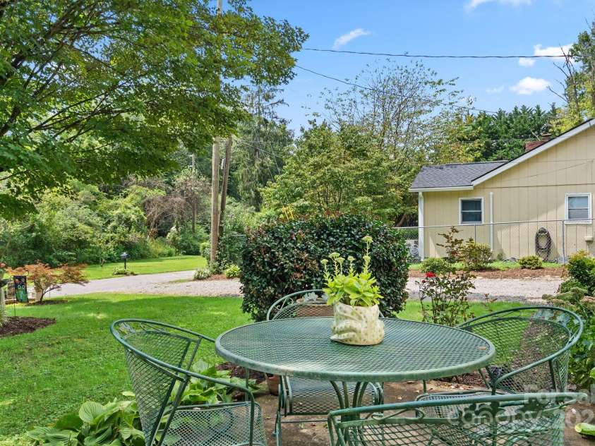 213 Old State Ten Road, Black Mountain, NC 28711.  MLS# CAR4294666, YatesRealty ID 34482. The yard offers a peaceful retreat with a patio area that’s perfect for outdoor dining or morning coffee. Surrounded by mature landscaping and greenery, it’s an inviting spot to relax, garden, or entertain gues