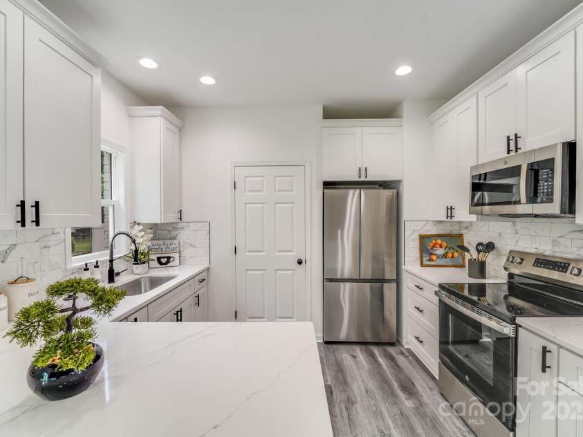 144 Walking Horse Run, Stanley, NC 28164.  MLS# CAR4288143, YatesRealty ID 34517. Flawless black and white brand new kitchen with new stainless steel appliances. Laundry is through that door.