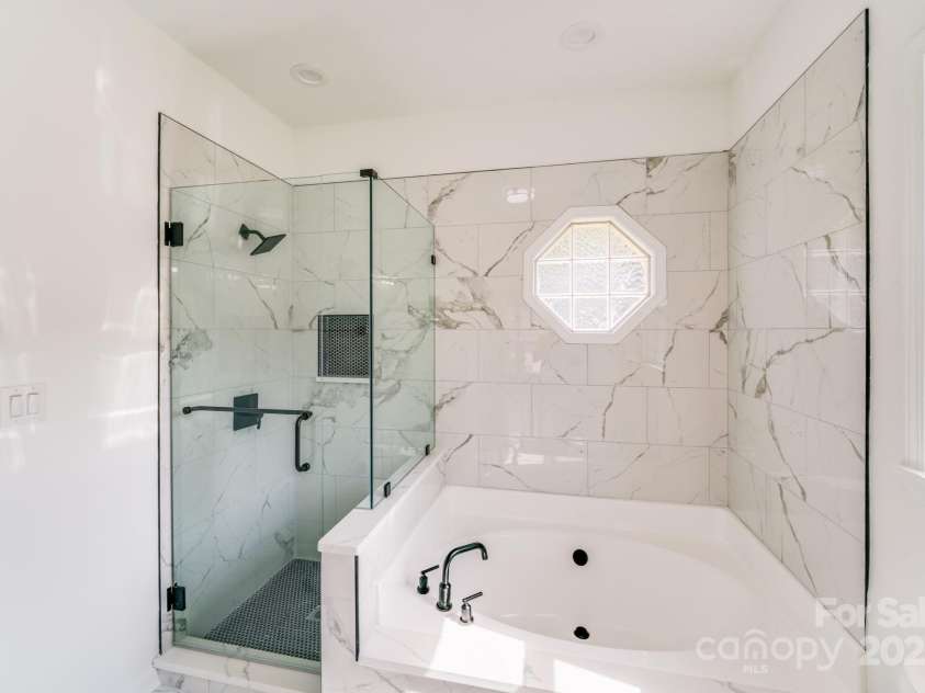 144 Walking Horse Run, Stanley, NC 28164.  MLS# CAR4288143, YatesRealty ID 34517. The gorgeous primary en-suite bathroom with separate garden tub and seamless glass enclosed shower!!