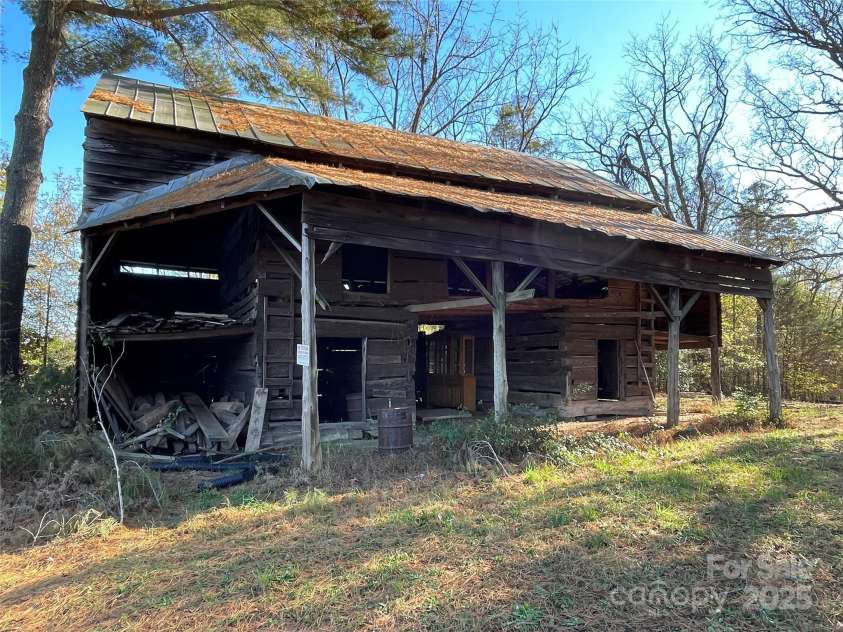 8725 Bringle Ferry Road, Salisbury, NC 28146.  MLS# CAR4218468, YatesRealty ID 3454. Large barn with metal roof.  Lumber storage at left. 