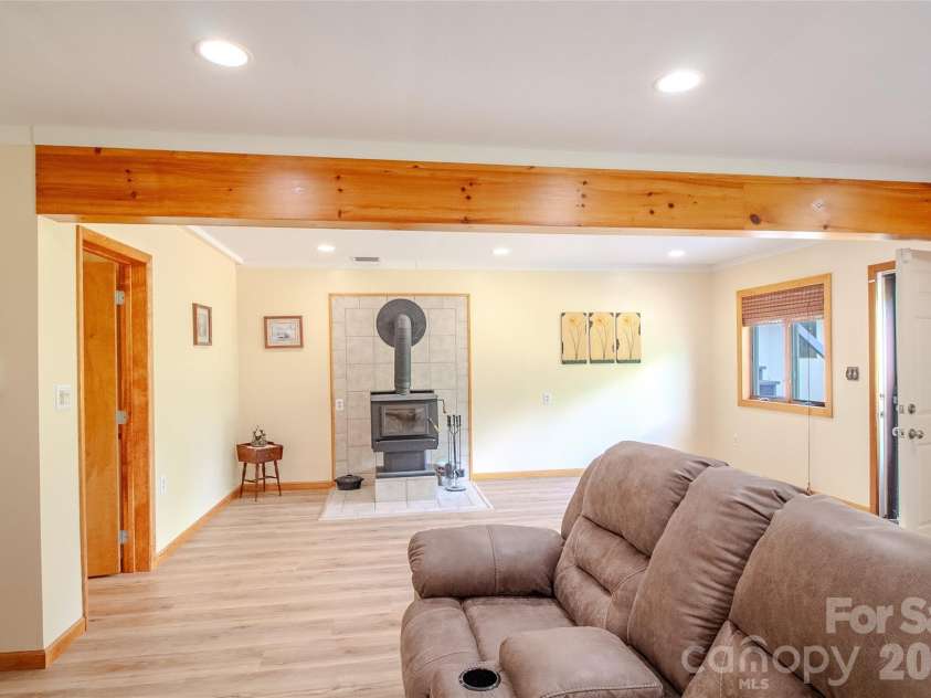 49 Jake Drive, Canton, NC 28716.  MLS# CAR4398234, YatesRealty ID 34618. Basement den area looking toward the wood burning stove