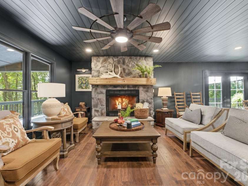 3819 Flat Mountain Road, Highlands, NC 28741.  MLS# CAR4397465, YatesRealty ID 34629. The dramatic stone fireplace and soaring windows create a warm, inviting gathering space filled with natural light and woodland views.