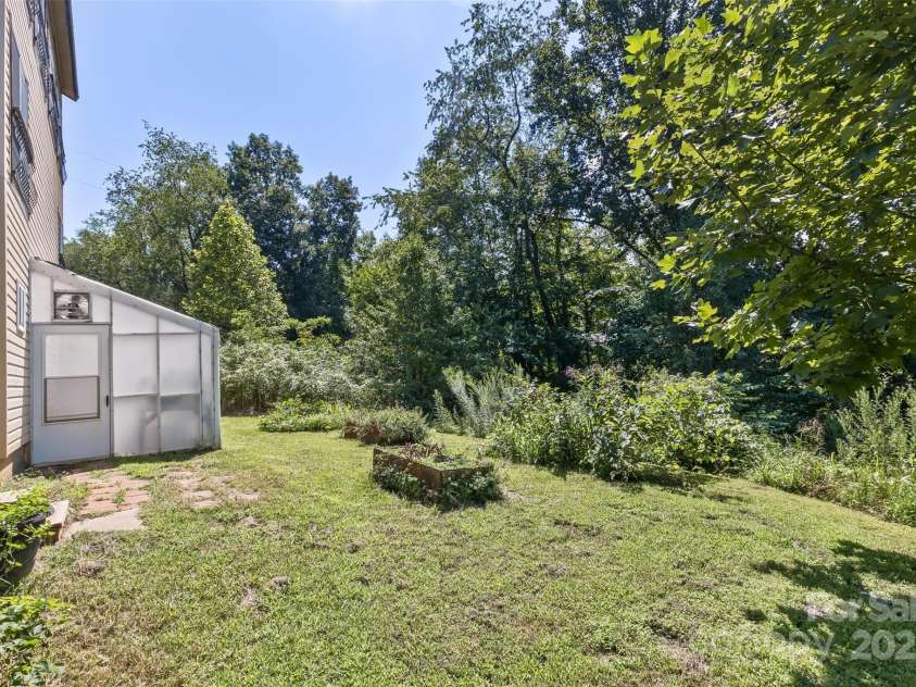 117 Old Dairy Drive, Leicester, NC 28748.  MLS# CAR4291419, YatesRealty ID 34700. The side yard, adjacent to the greenhouse, could be supplemented with additional raised beds or cultivate the land for maximum production from your garden.