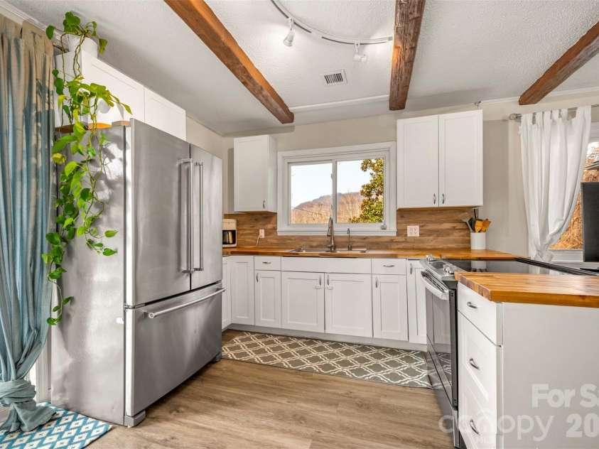 1685 Lynn Road, Columbus, NC 28722.  MLS# CAR4341868, YatesRealty ID 3472. Cozy kitchen with wood beams and butcher block countertops.  Notice those mountain views through the kitchen window?