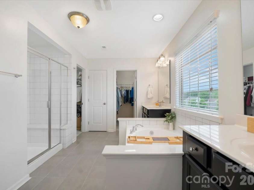 17534 Austins Creek Drive, Charlotte, NC 28278.  MLS# CAR4388620, YatesRealty ID 34731. Large walk-in shower with a seat for the mornings you need to linger. Two closets for the life you have both built separately and together. A primary bath that finally gives everyone exactly what they deserve.