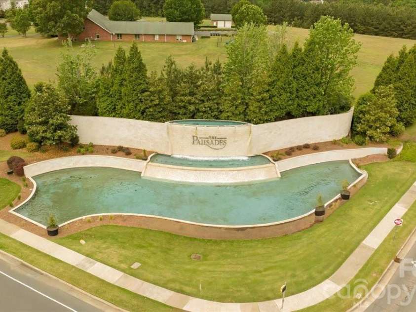 17534 Austins Creek Drive, Charlotte, NC 28278.  MLS# CAR4388620, YatesRealty ID 34731. The waterfall at the entrance to The Palisades sets the tone before you ever reach your front door — graceful, well maintained, and the kind of welcome that never gets old no matter how many times you drive past 