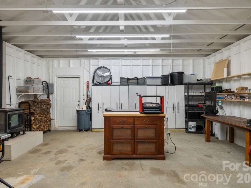 300 Licklog Mountain Trail, Burnsville, NC 28714.  MLS# CAR4399926, YatesRealty ID 34746. Refinished workshop with wood burning stove.  Space has endless possibilities......convert to extra living space, game room, office etc.
